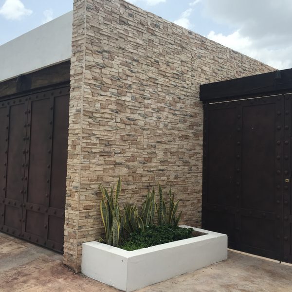 Finished wall clad in cast veneer stone